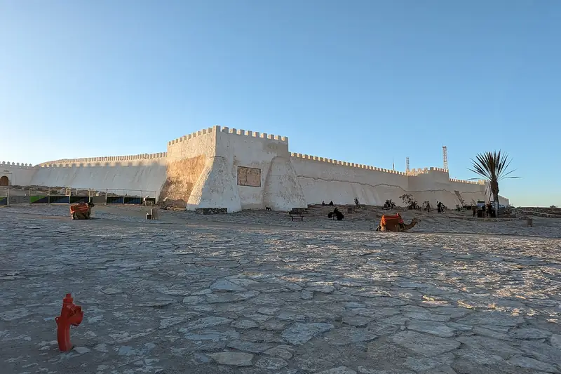 The restored walls of the Agadir Oufella kasbah on its hilltop under a blue sky
